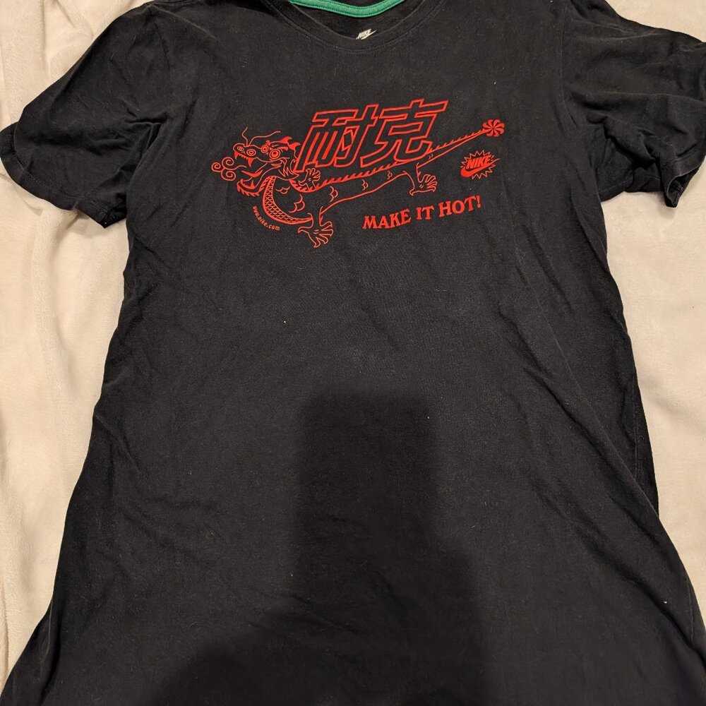Black Nike t-shirt with a red and orange Chinese dragon graphic and the phrase "